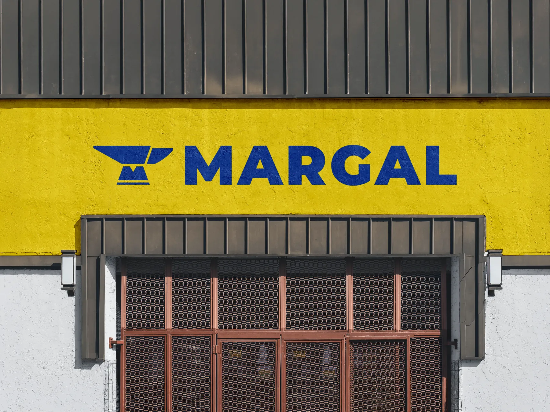 Rótulo amarillo de Margal en la fachada del taller